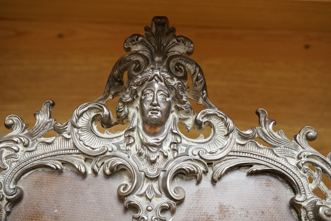 A cast brass putti double easel photo frame, 34cm high